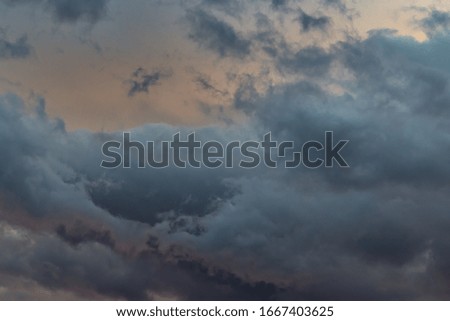  POA, SAO PAULO, BRAZIL   -  wall of clouds with shadows in various shades of gray, under the orange twilight sky.