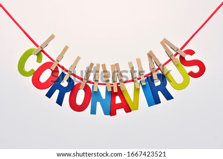 The word coronavirus made with colored letters, on a clothesline caught with clothespins