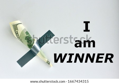 Money duct taped to the wall with text I am winner.Conceptual photo. Background for sticker, t-shirt screen printing. 