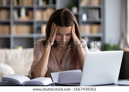 Stressed young woman holding head in hands, feeling desperate about financial problems, dismissive notice, failed test. Depressed businesswoman shocked by bank loan rejection, domestic bills. Royalty-Free Stock Photo #1667438362