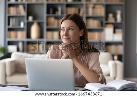 Head shot young dreamy woman sitting at table, distracted from computer work. Lost in thoughts lady looking away, planning visualizing future at home. Entrepreneur enjoying break pause time. Royalty-Free Stock Photo #1667438671
