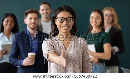 Excited African American businesswoman employer stretch get acquainted with job applicant or candidate, overjoyed diverse business team meet newcomer, internship, recruitment concept Royalty-Free Stock Photo #1667438722