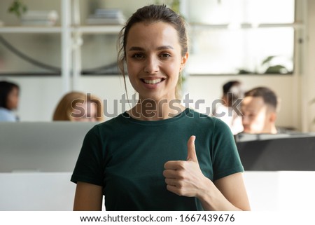 Profile picture of happy millennial Caucasian girl employee show thumbs up recommend good company service, portrait of smiling satisfied female client give recommendation, posing in office