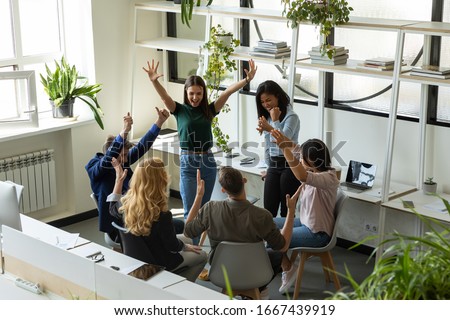 Overjoyed diverse multiethnic businesspeople have fun celebrate shared group achievement in office, excited multiracial colleagues engaged in teambuilding activity, motivated for results at briefing Royalty-Free Stock Photo #1667439919