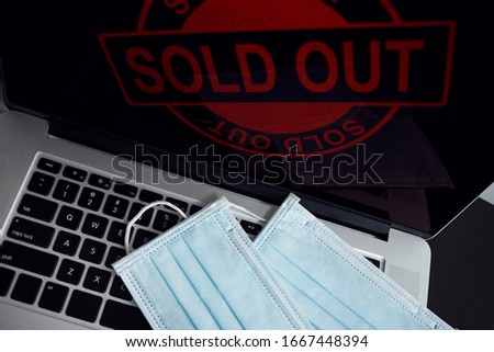 Two surgical masks are placed on your computer, while you are trying to find more of them online by browsing the Internet.Unfortunately they are all sold out, because of new virus.