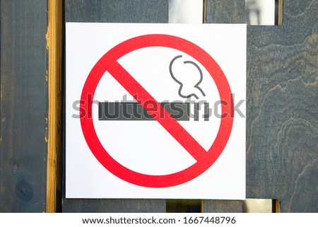 No smoking sign on a wooden door.
