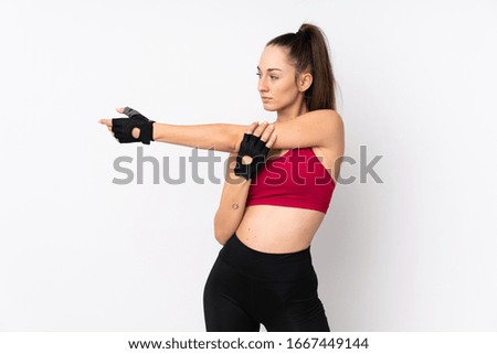 Young sport brunette woman over isolated white background stretching arm