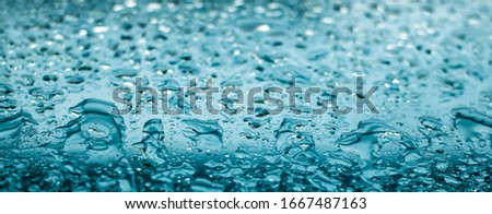 Water drops on glass surface as abstract background, close-up