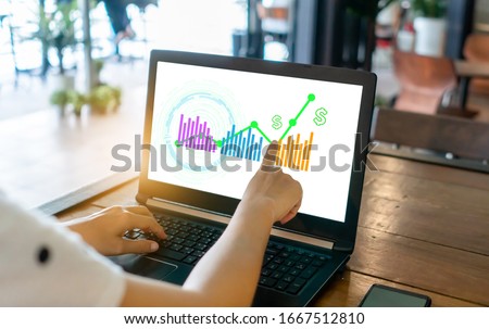 Fintech financial icon and market stock graph pop up in computer screen monitor with finger point. Financial business technology freedom dream life concept.