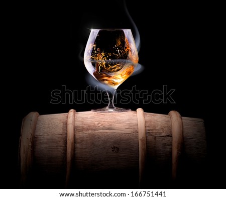 Cognac glass shrouded in a smoke on a black background
