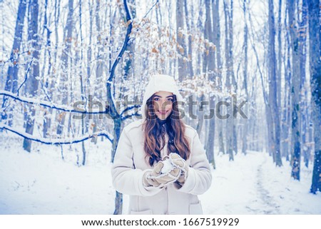 Girl playing with snow in park. Winter woman clothes. Winter woman snow. Winter woman fan. Global cooling