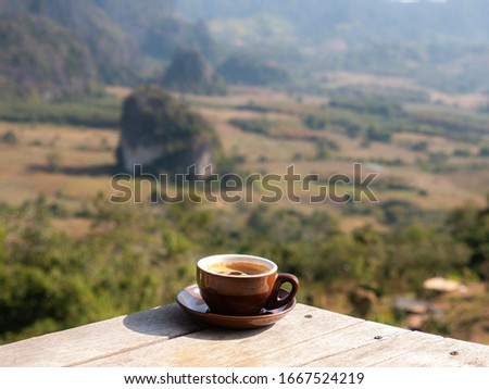 The Brown Cofffee Cup on The Wooden Table behind The National Park Mountain