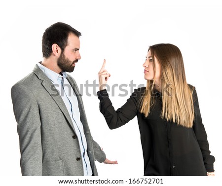 Girl doing the horn sign at her boyfriend over white background 