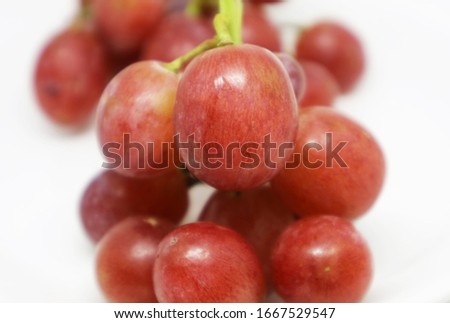 Close-up picture of a sweet pink grape isolated Soft blur background
