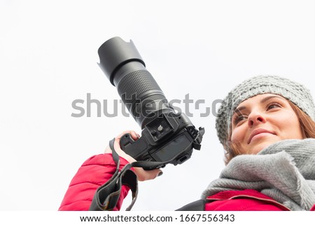 Happy looking teenager holding a dslr camera