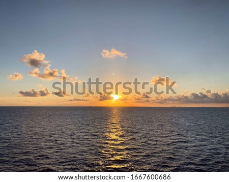 Landscape. A view of the blue ocean at sunset. Beautiful natural background. Horizon line of the blue sea and sky with clouds. Horizontal, free space, nobody. Concept of natural beauty.