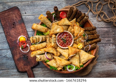 Stock image of a platter, contains spring roll, samosa and kebabs , ready to eat