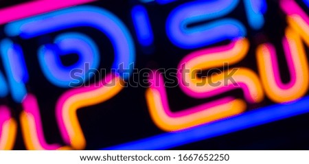 Neon background. Neon signs and words of different colors at night on the street. Electric color lighting for fashion and beauty design.