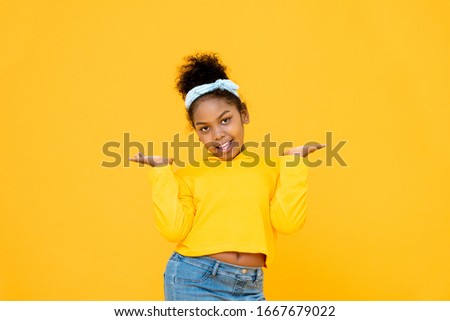 Young cute African mixed race girl smiling and doing open palms gesture isolated on colorful yellow background