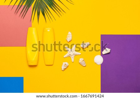 Yellow bottles of sunscreen cream, tropical palm leaves, shells, starfish on colorful background top view flat lay copy space. Sun protection Summer background vacation travel concept Summer cosmetics