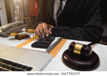 justice and law concept.businessman or lawyer or accountant working on accounts using a smart phone laptop   calculator  Royalty-Free Stock Photo #1667703379