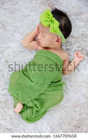 Close up cute Newborn wearing bow headband on wool carpets, fashion concept