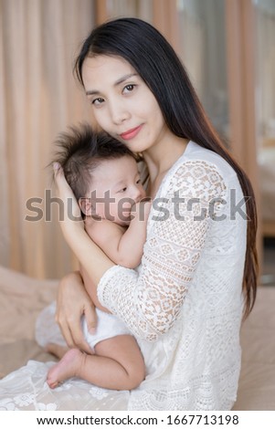 portrait of a happy mother and her baby looking at you