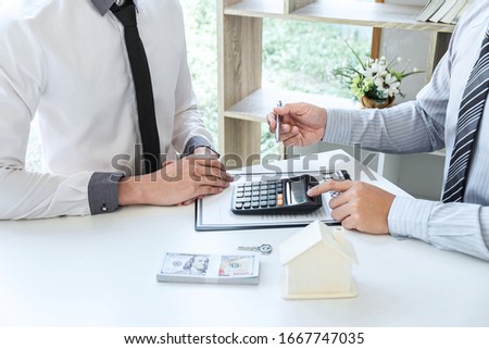 Sale purchase contract to buy a house, Real estate agent are presenting home loan and giving keys to customer after signing contract to buy house with approved property application form.
