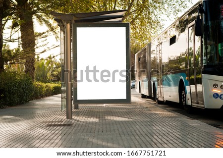 White blank vertical billboard at the bus stop on the city street. In the background of buses and roads. Sketch. Poster on the street next to the road Royalty-Free Stock Photo #1667751721