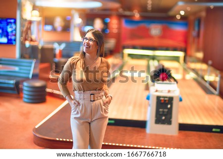 Young beautiful woman smiling happy and confident. Standing with smile on face at bowling