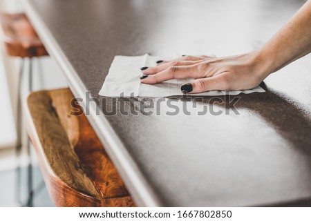 concept of disinfecting surfaces from bacteria or viruses, hand cleaning bar table with disinfectant wet wipe  Royalty-Free Stock Photo #1667802850