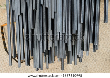 Racks of metal profiles. Metal is stored in an open warehouse. Wet on the street. Background made of iron for shooting flatleys on the table