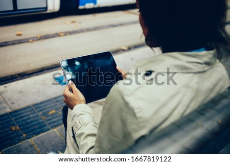 Female influencer watching online video streams during free time for online networking on modern touch pad with roaming internet connection, woman reading web news on digital tablet with blank screen