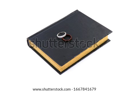 ring on the old black book isolated on white