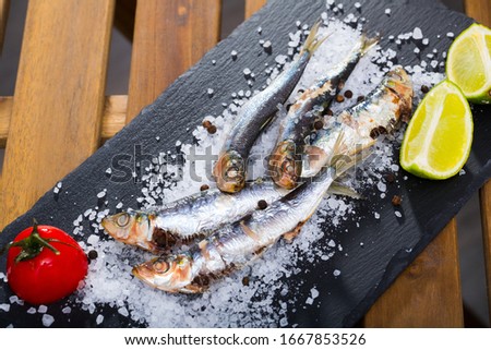 Picture of  tasty dish of baked sprat baked in the oven on a pillow of sea salt