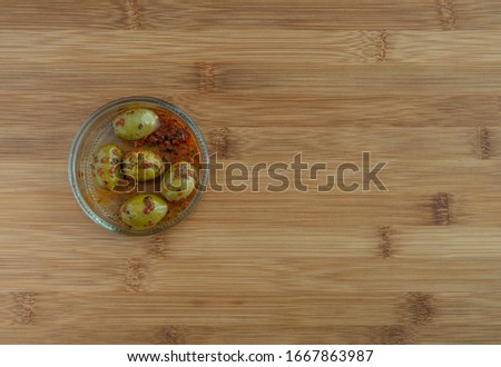 Marinated olives in bowl on wooden table, high resolution photo .