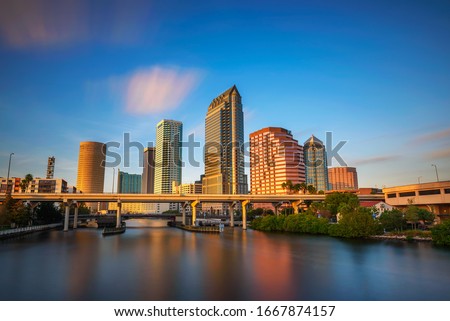 The skyline of downtown Tampa at sunset with Hillsborough river in the foreground. Long exposure.