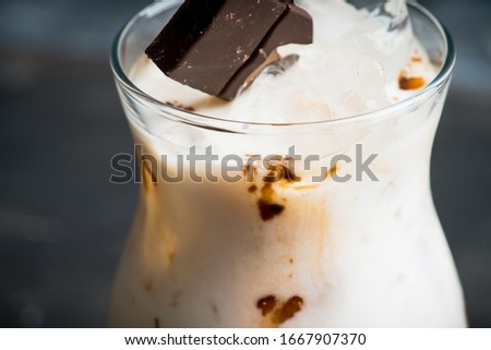 Creamy cocktail with ice and slice of chocolate. Selective focus. Shallow depth of field.