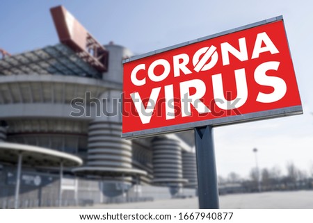 Red warning sign for Covid-19 in front of closed stadium. Concept of cancellation of sporting events due to corona virus medical emergency. Purposely blurred stadium in the background. Royalty-Free Stock Photo #1667940877