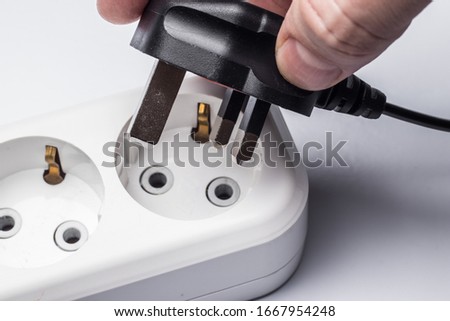 Different standards for electrical outlets. Unsuitable connector and plug in the hand of a person. Incompatibility, concept
 Royalty-Free Stock Photo #1667954248