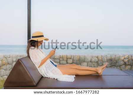 Portrait young asian woman using smart mobile phone around outdoor beach sea ocean