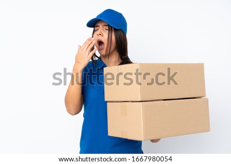 Young delivery brunette girl over isolated white background yawning and covering wide open mouth with hand