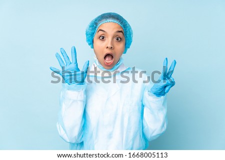 Young surgeon Indian woman in blue uniform counting seven with fingers