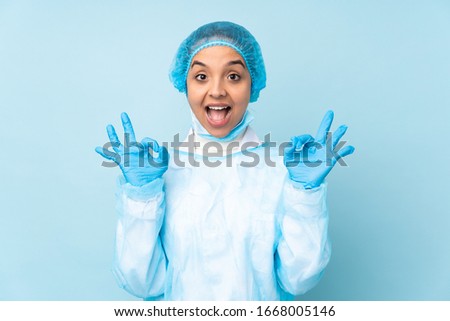 Young surgeon Indian woman in blue uniform showing an ok sign with fingers