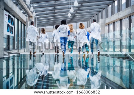 Rear view of group of doctors running, corona virus concept.