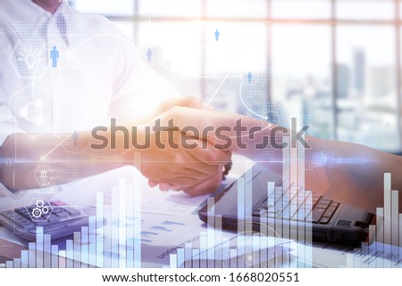 Double exposure of handshake and urban city,with business document.digital diagram chart and graph