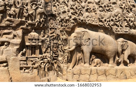 Descent of the Ganges: A giant open-air rock bas relief carved on two monolithic rocks in Mahabalipuram. It contains sculptures of animals, God, people and half-humans carved in the rock relief. Royalty-Free Stock Photo #1668032953