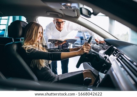 Young woman testing a car from a car showroom Royalty-Free Stock Photo #1668042622