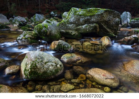 Autumn river. Clear water shows rocks on the bottom. Stream of water between rocks. Royalty-Free Stock Photo #1668072022