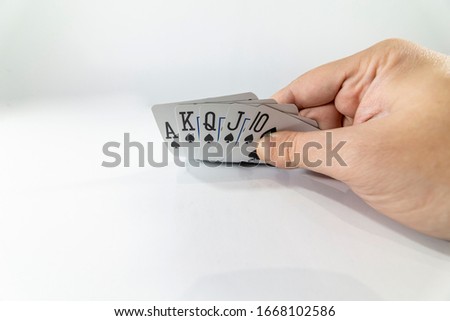 Low angle view of a hand showing poker cards isolated on white background. Gambling concept.